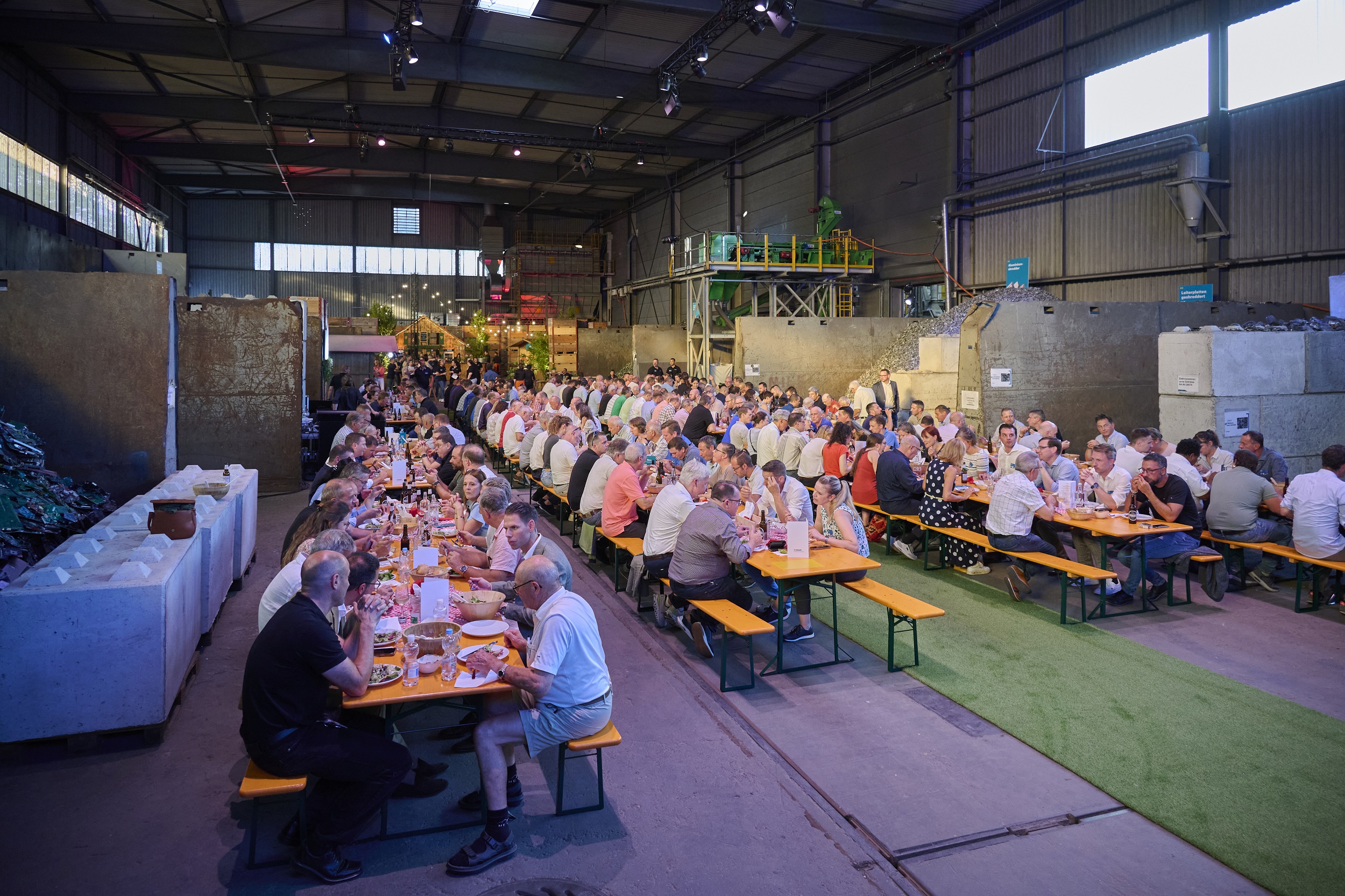 Feststimmung und Einweihungsfeier in der Betriebshalle. Besucher beim Essen.